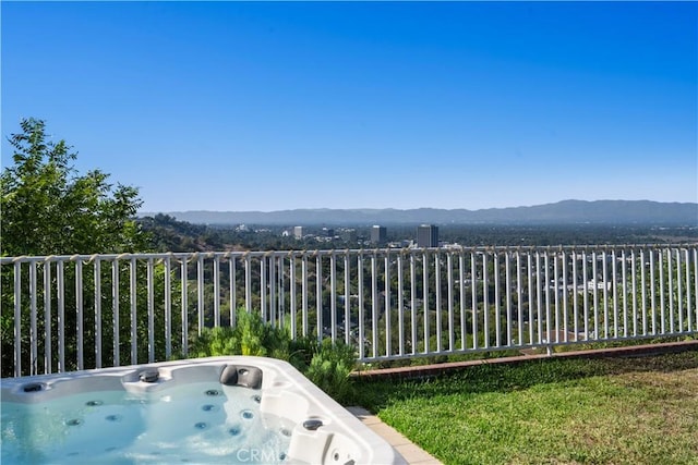 balcony featuring a hot tub and a mountain view