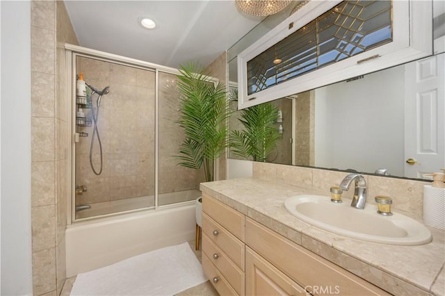 bathroom with vanity and bath / shower combo with glass door