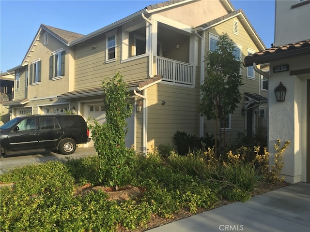 view of front facade featuring a balcony and a garage