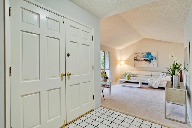 entryway featuring lofted ceiling, light carpet, and a textured ceiling