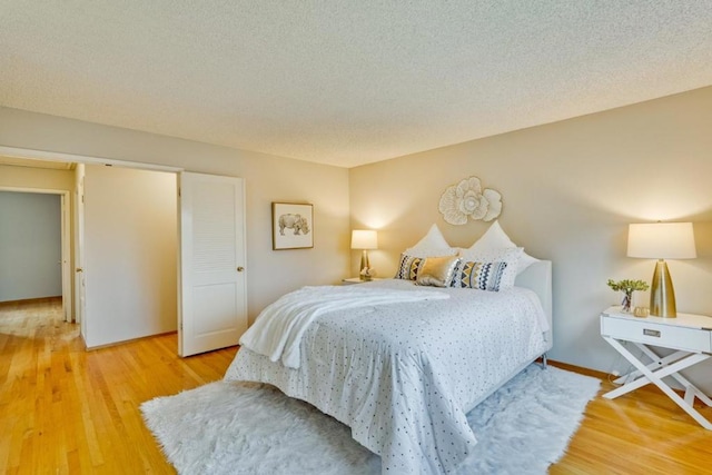 bedroom featuring hardwood / wood-style floors and a textured ceiling