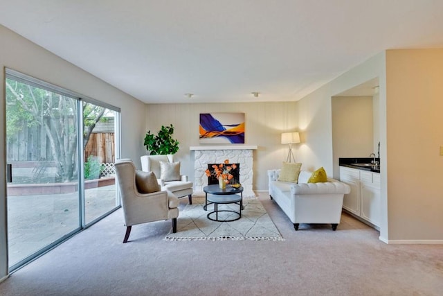 living room with sink, light carpet, and a fireplace