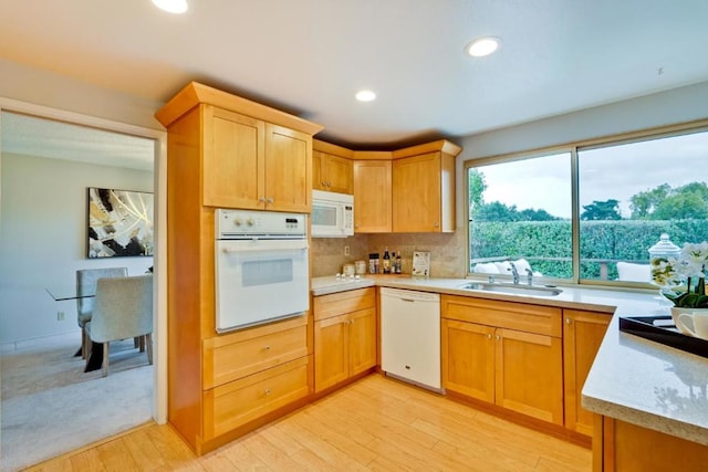 kitchen featuring white appliances, light hardwood / wood-style floors, sink, and backsplash