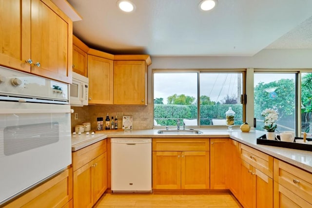 kitchen featuring light wood-type flooring, white appliances, sink, and a wealth of natural light