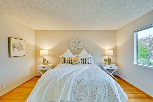 bedroom featuring a textured ceiling and light wood-type flooring