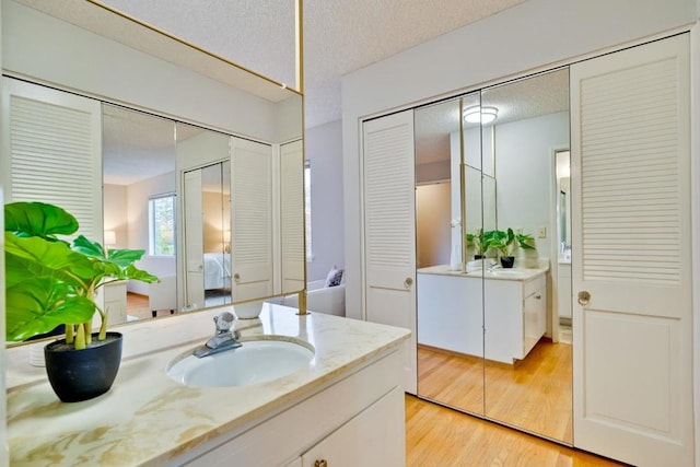 bathroom featuring wood-type flooring, a textured ceiling, and vanity