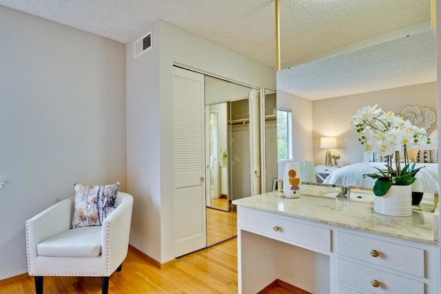 bathroom featuring hardwood / wood-style flooring, vanity, and a textured ceiling