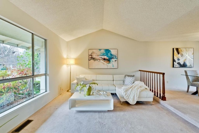 living room with vaulted ceiling, carpet flooring, and a textured ceiling