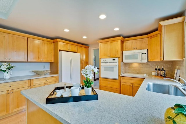 kitchen featuring sink, decorative backsplash, white appliances, light stone countertops, and light wood-type flooring