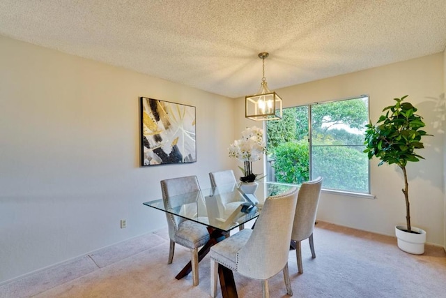 dining room with light carpet, a notable chandelier, and a textured ceiling