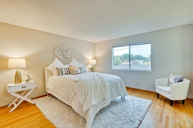 bedroom featuring hardwood / wood-style flooring and a textured ceiling