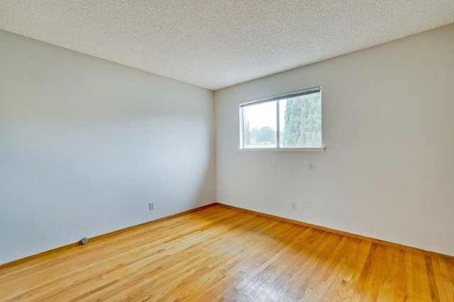 empty room featuring wood-type flooring and a textured ceiling