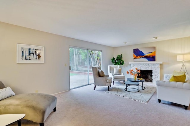 carpeted living room with a stone fireplace