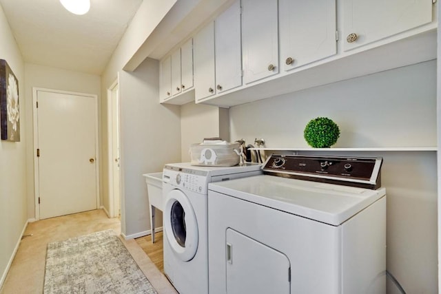 laundry room with washer and clothes dryer and cabinets