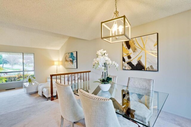 dining room with vaulted ceiling, carpet flooring, a textured ceiling, and an inviting chandelier