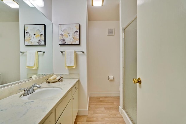 bathroom with walk in shower, wood-type flooring, and vanity