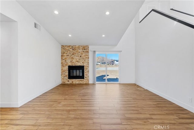 unfurnished living room featuring a large fireplace and light hardwood / wood-style flooring