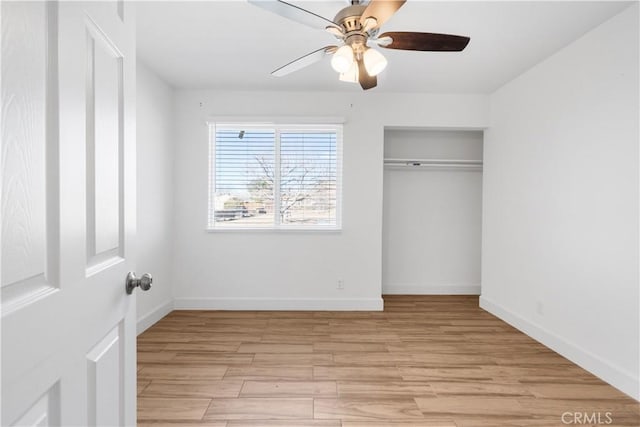 unfurnished bedroom with ceiling fan, a closet, and light wood-type flooring