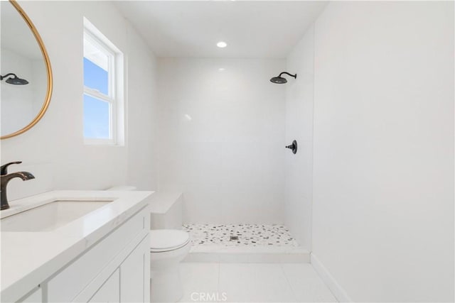 bathroom with vanity, tile patterned floors, toilet, and a tile shower