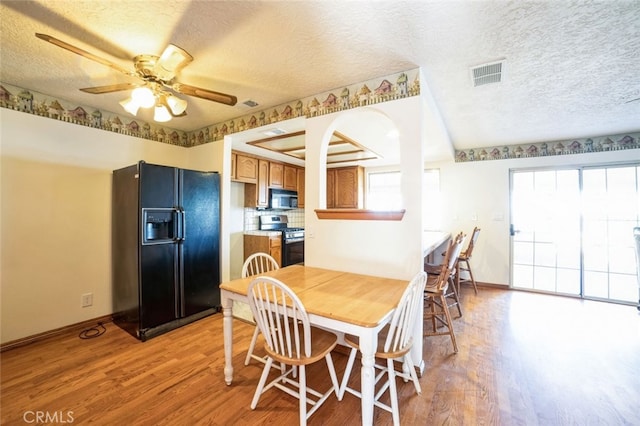 dining space featuring ceiling fan, light hardwood / wood-style floors, and a textured ceiling