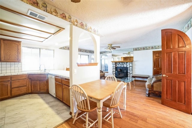 dining space featuring a textured ceiling, ceiling fan, and light hardwood / wood-style flooring