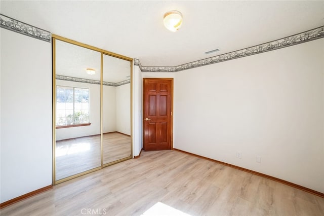 unfurnished bedroom featuring a closet and light hardwood / wood-style flooring