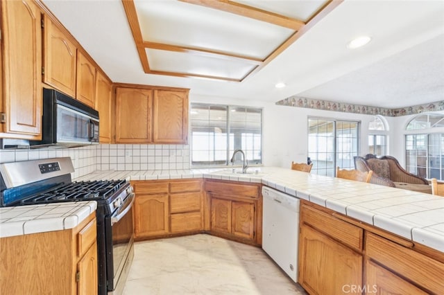 kitchen featuring tile countertops, dishwasher, sink, decorative backsplash, and gas stove