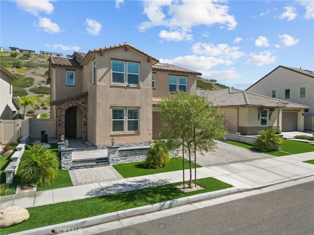 mediterranean / spanish-style home featuring a front yard