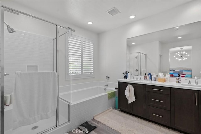 bathroom featuring vanity, a notable chandelier, and independent shower and bath