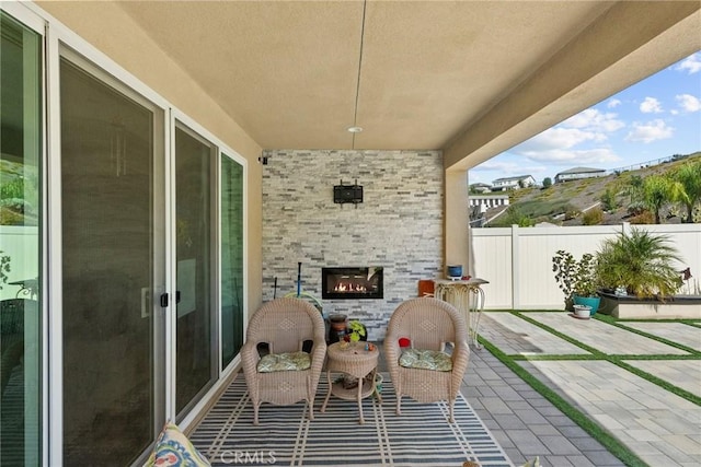 view of patio with an outdoor stone fireplace