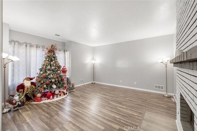 interior space featuring a brick fireplace and hardwood / wood-style floors