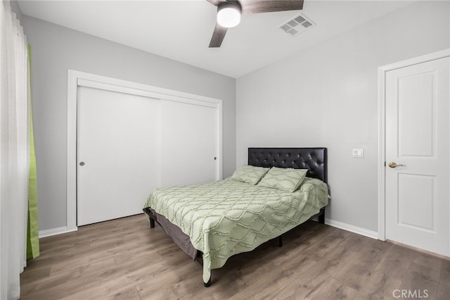 bedroom featuring hardwood / wood-style floors, ceiling fan, and a closet