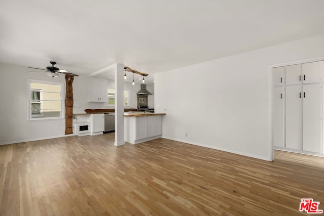 unfurnished living room featuring ceiling fan and light wood-type flooring