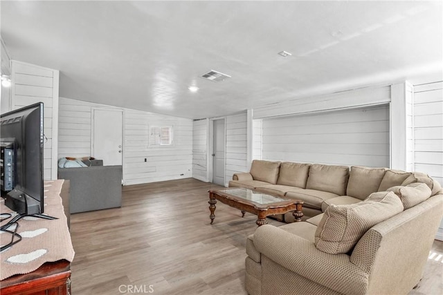 living room with hardwood / wood-style floors and wood walls