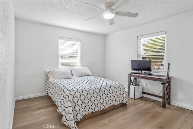 bedroom featuring ceiling fan, a textured ceiling, and light wood-type flooring