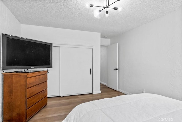 bedroom with hardwood / wood-style floors, a closet, and a textured ceiling