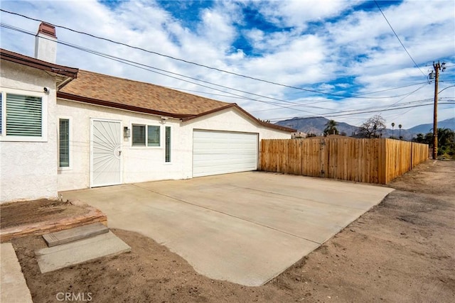 view of property exterior with a garage and a mountain view