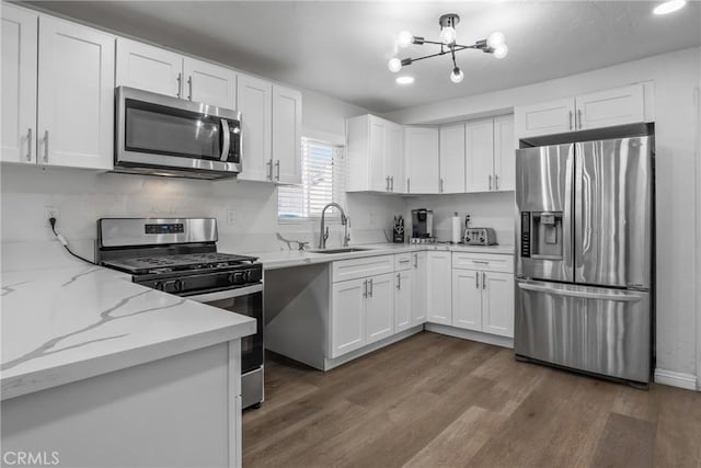 kitchen featuring white cabinetry, appliances with stainless steel finishes, sink, and light stone counters