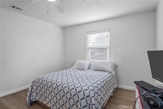 bedroom featuring hardwood / wood-style flooring, a textured ceiling, and ceiling fan