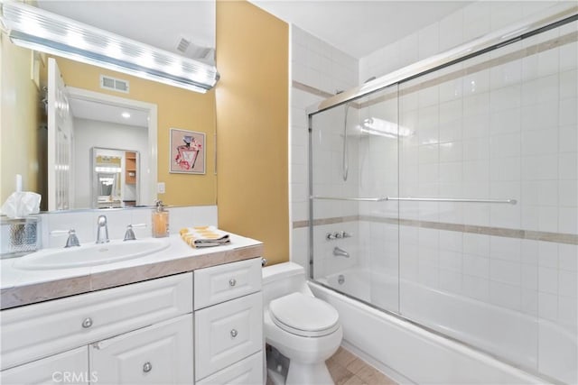 full bathroom with vanity, toilet, and combined bath / shower with glass door