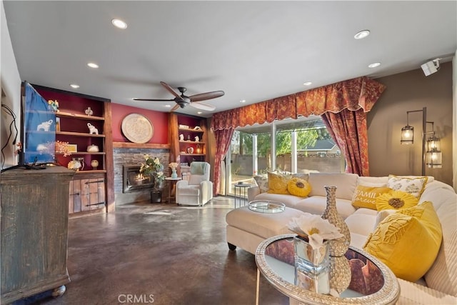 living room with built in shelves, a fireplace, and ceiling fan