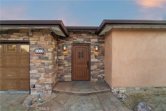 exterior entry at dusk with a garage