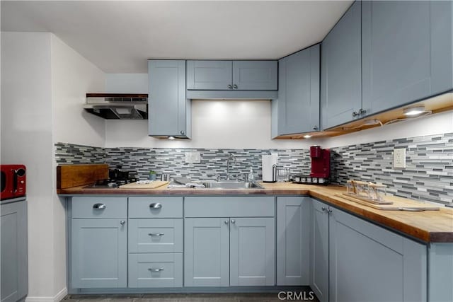 kitchen with wood counters, sink, and backsplash