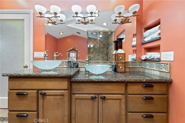 bathroom featuring a shower with door, vanity, lofted ceiling, and a chandelier