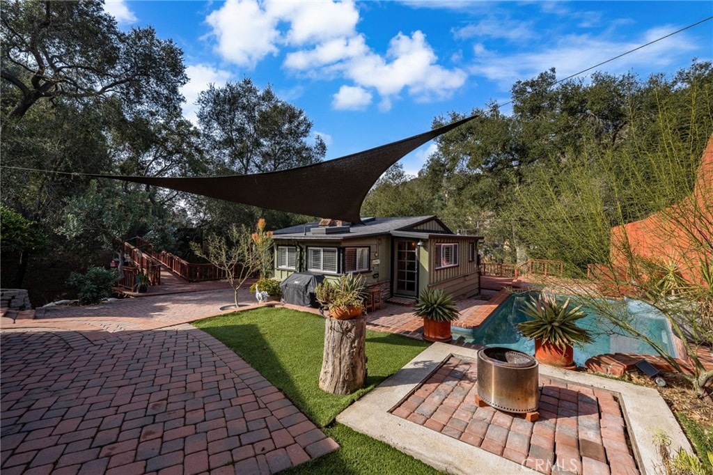 back of house with a pool and a patio