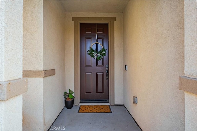 doorway to property featuring stucco siding