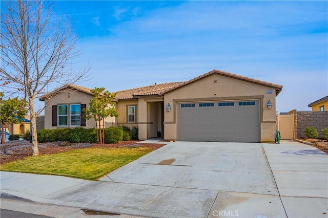 view of front of property with an attached garage, a tile roof, driveway, stucco siding, and a front lawn