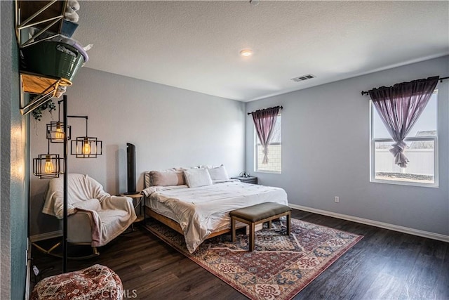 bedroom with dark wood-type flooring and a textured ceiling