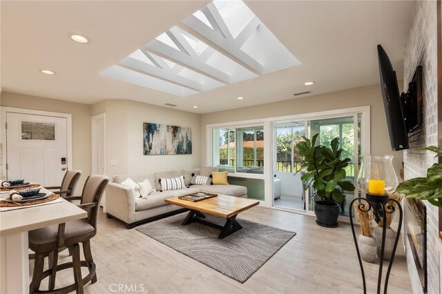 living room featuring a skylight and light wood-type flooring