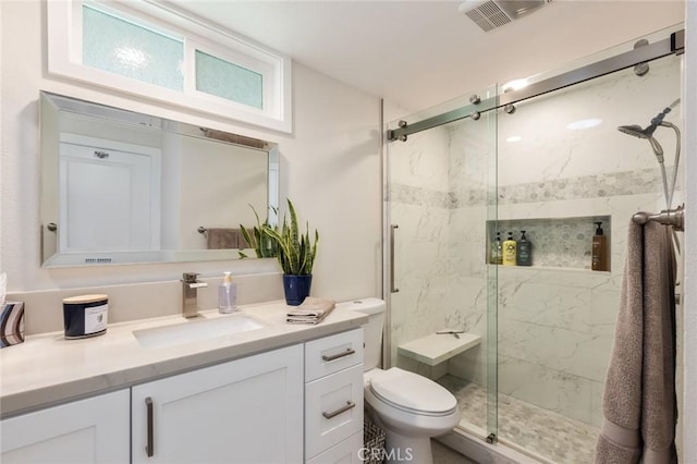 bathroom featuring vanity, toilet, and a shower with shower door